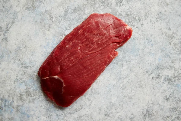 Trozo de carne fresca cruda colocada sobre fondo de piedra gris —  Fotos de Stock