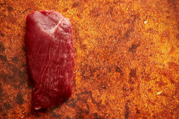 Kawałka surowej wołowiny świeży stek umieszczone na tle zardzewiały — Zdjęcie stockowe