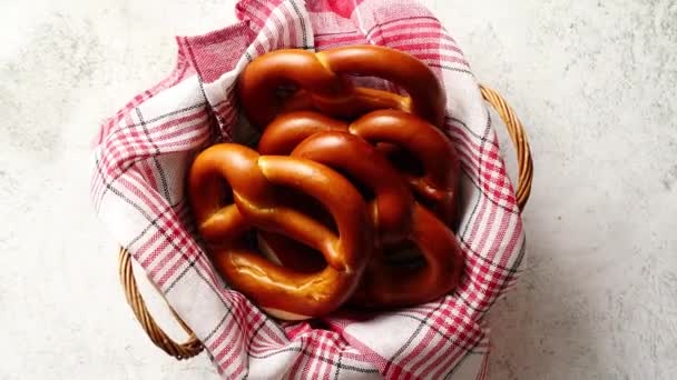 Korg med röd och vit rutig servett fylld med färsk brun pretzels — Stockvideo