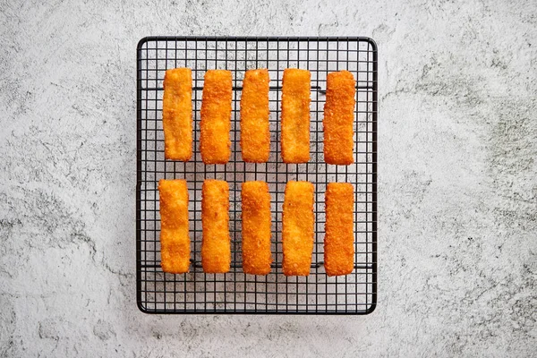 Rows of golden fried fresh fish fingers fillets — Stock Photo, Image