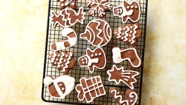 Fresh baked Christmas shaped gingerbread cookies placed on steel grill — Stock Video