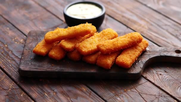 Montón de dedos dorados de pescado frito con salsa de ajo blanco — Vídeos de Stock