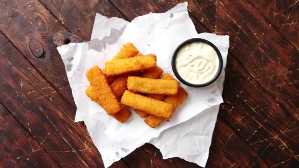 Montón de dedos dorados de pescado frito con salsa de ajo blanco — Vídeos de Stock