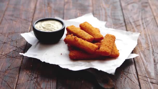 Pile of golden fried fish fingers with white garlic sauce — Stock Video