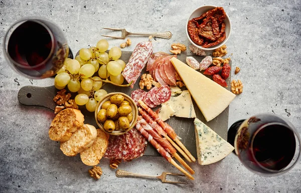 Tavola degli snack freddi con salumi, uva, vino, vari tipi di formaggio — Foto Stock