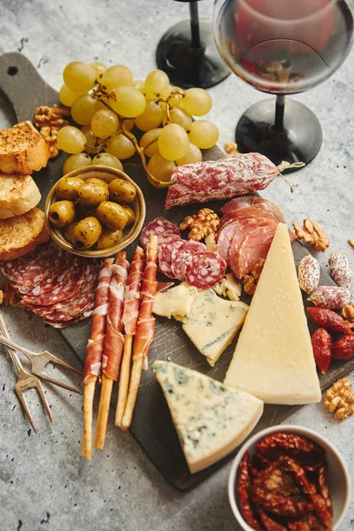Cold snacks board with meats, grapes, wine, various kinds of cheese — Stock Image Cold snacks board with meats, grapes, wine, various kinds of cheese Stock Photo
