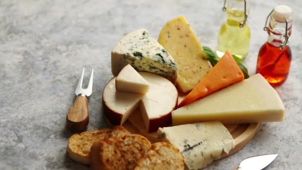 Diverse soorten kaas geserveerd op rustieke houten plank — Stockvideo