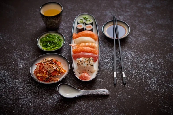Surtido de comida asiática. Varios rollos de sushi colocados en placas de cerámica — Foto de Stock