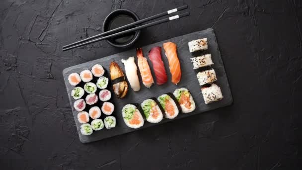 Sushi Rolls Set met zalm en tonijn geserveerd op Black Stone Board — Stockvideo