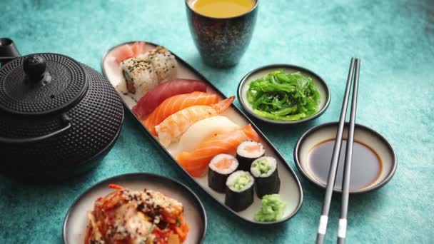 Assortiment alimentaire asiatique. Divers rouleaux de sushi placés sur des plaques en céramique — Video