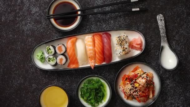 Surtido de comida asiática. Varios rollos de sushi colocados en placas de cerámica — Vídeo de stock
