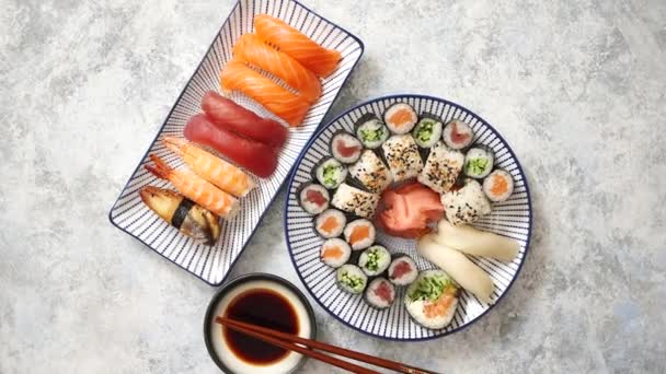 Surtido de comida asiática. Varios rollos de sushi colocados en placas de cerámica — Vídeos de Stock