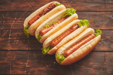 Tasty american hot dogs assorted in row. Placed on wooden table clipart