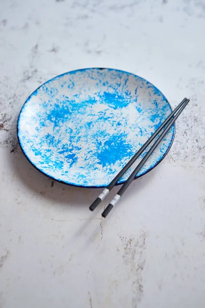 Modré ručně malované keramický servírovací talíř s dřevěnými hůlkami na straně — Stock fotografie