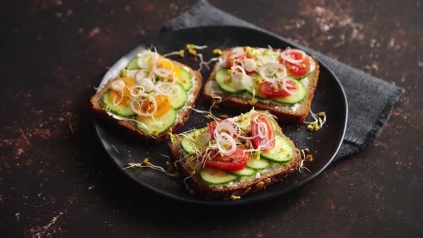 Tostadas saludables con pepino, tomates y brotes de feta y rábano desmenuzados — Vídeo de stock