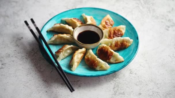 Traditionelle asiatische Knödel Gyozas auf türkisfarbenem Keramikteller — Stockvideo