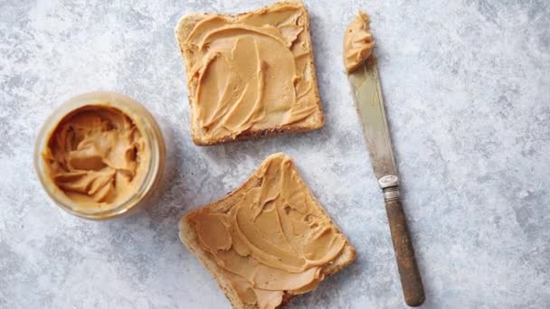 Duas saborosas torradas de manteiga de amendoim colocadas na mesa de pedra — Vídeo de Stock