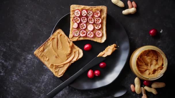 Torradas pão com manteiga de amendoim caseiro servido com fatias frescas de cranberries — Vídeo de Stock