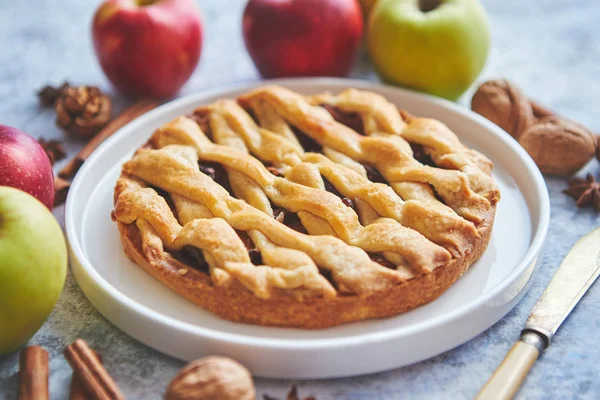 Tasty sweet homemade apple pie cake with cinnamon sticks, walnuts and apples