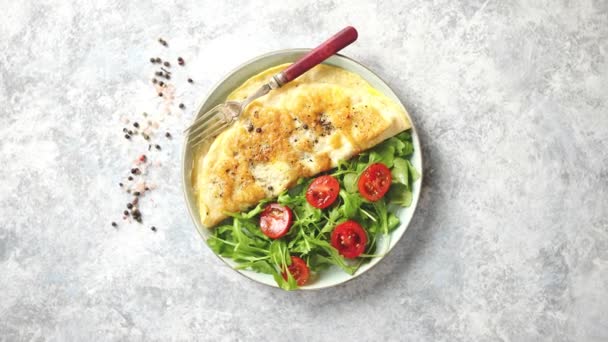 Tortilla de huevo clásica servida con tomate cherry y ensalada de rúcula al lado — Vídeos de Stock