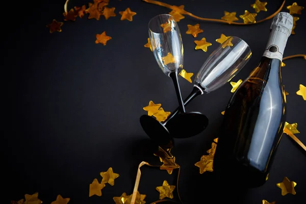 Szemüveg és üveg pezsgő arany szerpentinekkel és konfettivel — Stock Fotó