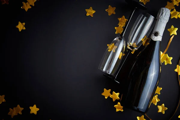 シャンパンのグラスとボトルに黄金のサーペンタインとコンフェッティ — ストック写真