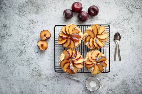 Hausgemachte Crumble Tarts mit frischen Pflaumenscheiben auf Eisengrill — Stockfoto