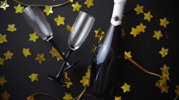 Bril en fles champagne met gouden serpentines en confetti — Stockvideo