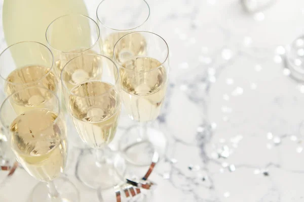 Şampanya bardakları ve şişe beyaz mermer arka planda — Stok fotoğraf