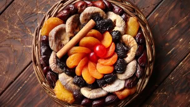 Mezcla de frutos secos en una pequeña canasta de mimbre sobre mesa de madera — Vídeos de Stock