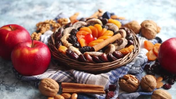 Zusammensetzung von getrockneten Früchten und Nüssen in einer kleinen Weidenschale auf einem Steintisch — Stockvideo
