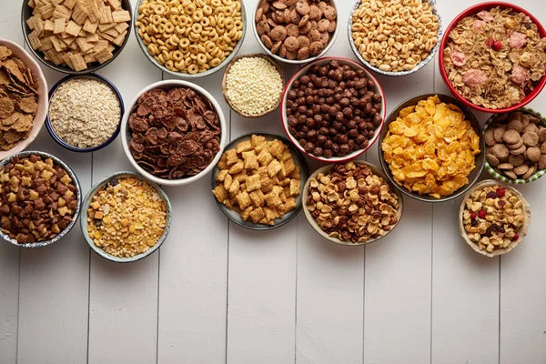 Assortimento di diversi tipi di cereali posti in ciotole di ceramica sulla tavola — Foto Stock