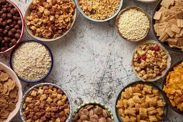 Surtido de diferentes tipos de cereales colocados en cuencos de cerámica en la mesa —  Fotos de Stock