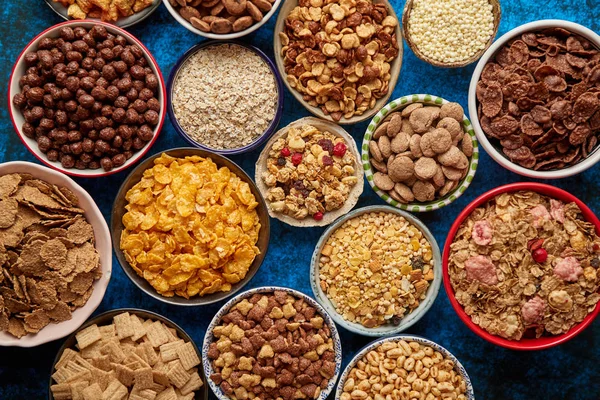 Sortimento de diferentes tipos de cereais colocados em tigelas de cerâmica na mesa — Fotografia de Stock