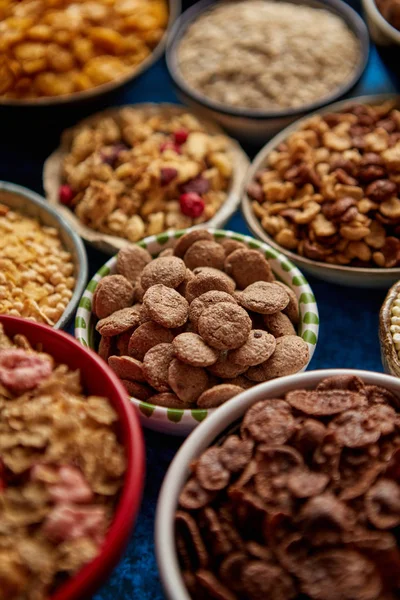 Assortiment van verschillende soorten granen geplaatst in keramische kommen op tafel — Stockfoto