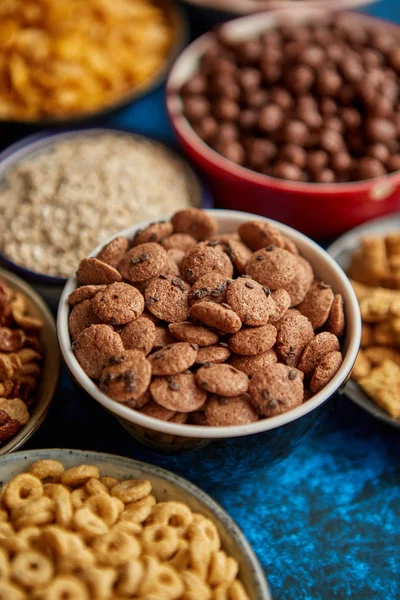 Surtido de diferentes tipos de cereales colocados en cuencos de cerámica en la mesa — Foto de Stock