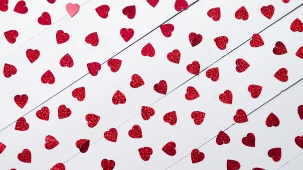 Composição do Dia dos Ventiladores. Lantejoulas em forma de coração colocadas na mesa de madeira branca — Vídeo de Stock