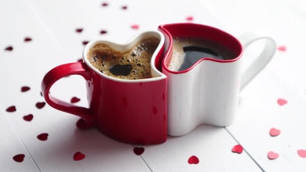 Δύο φλιτζάνια καφέ σε σχήμα καρδιάς που συνδέεται με το άλλο. — Αρχείο Βίντεο