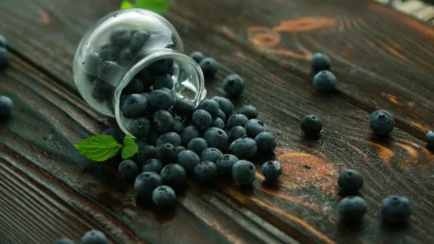 Zbliżenie Blueberry Rozrzut Szklany Dzbanek Mokry Ciemny Drewniany Stół — Wideo stockowe