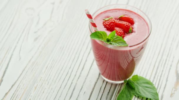 Glas mit Smoothie und Schüssel Erdbeeren — Stockvideo