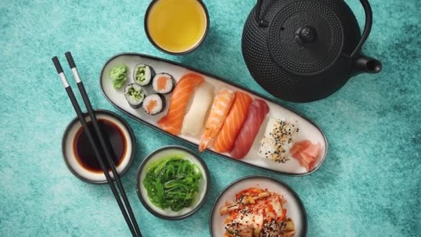 Uma variedade de comida asiática. Vários rolos de sushi colocados em placas de cerâmica — Vídeo de Stock