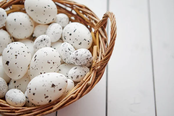 Korg av vita prickade påsk ägg i brun flätad korg — Stockfoto