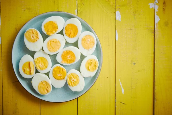 Варёные куриные яйца на голубой керамической тарелке. Концепция пасхальных праздников — стоковое фото