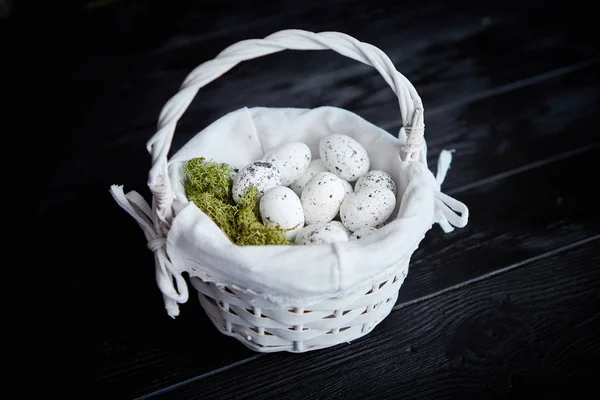 Vaktelägg i ett bo på en svart rustikt trä bakgrund. Påsk symboler — Stockfoto