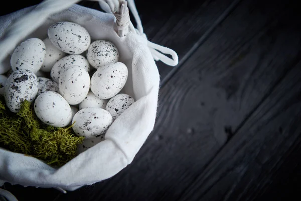 Vaktelägg i ett bo på en svart rustikt trä bakgrund. Påsk symboler — Stockfoto