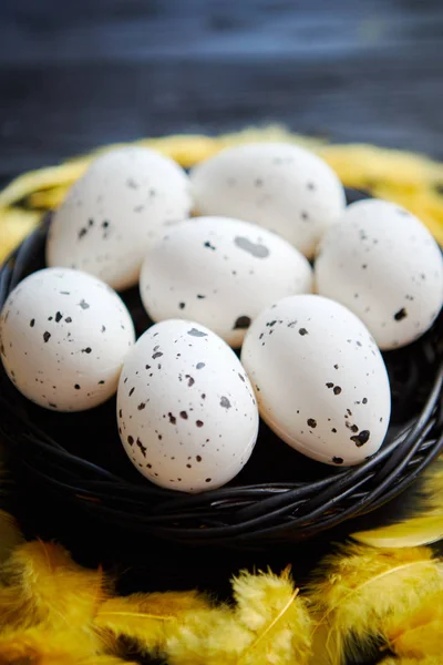 Ganze Hühnereier in einem Nest auf schwarzem rustikalem Holzgrund. Ostersymbole — Stockfoto