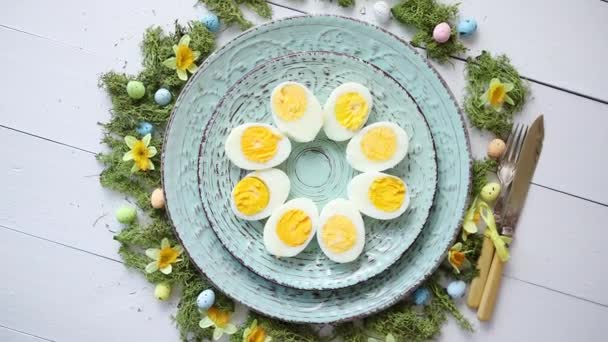 Ostergedeck mit Blumen und Eiern. Dekorative Teller mit gekochten Eiern — Stockvideo
