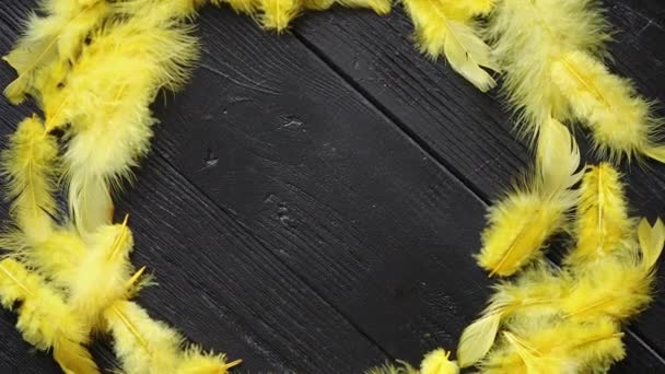 Couronne décorative colorée de plumes de Pâques sur fond de table en bois noir — Video