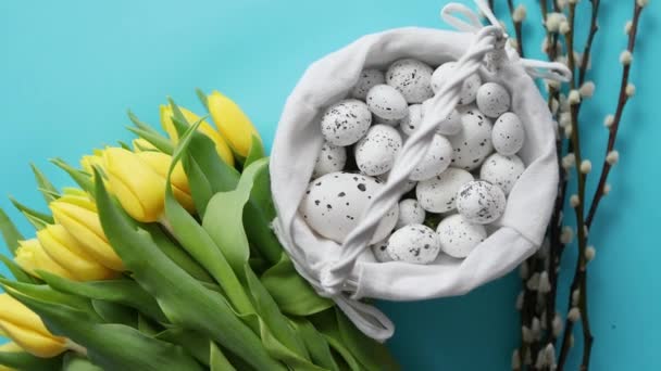 Decorazione festiva con uova di Pasqua e tulipani gialli sopra il blu — Video Stock