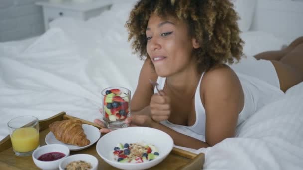 Soñando mujer teniendo dulce comida en la cama — Vídeo de stock